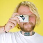 young blond man with photo camera